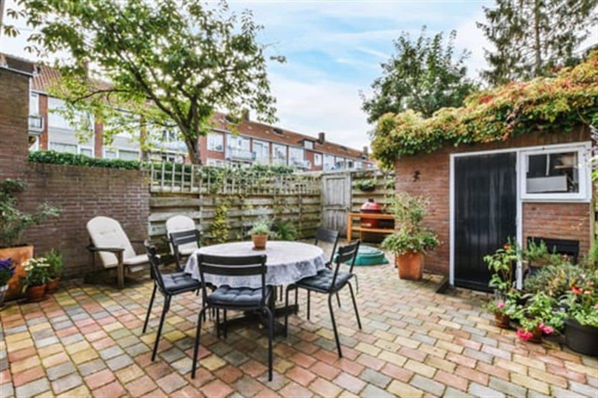 Natural flagstone patio with outdoor furniture surrounded by planted garden beds