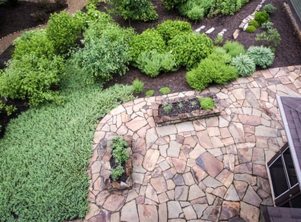 Flagstone patio and landscaped planting beds installed by Cat's Landscape and Hardscape LLC in Canton, Georgia
